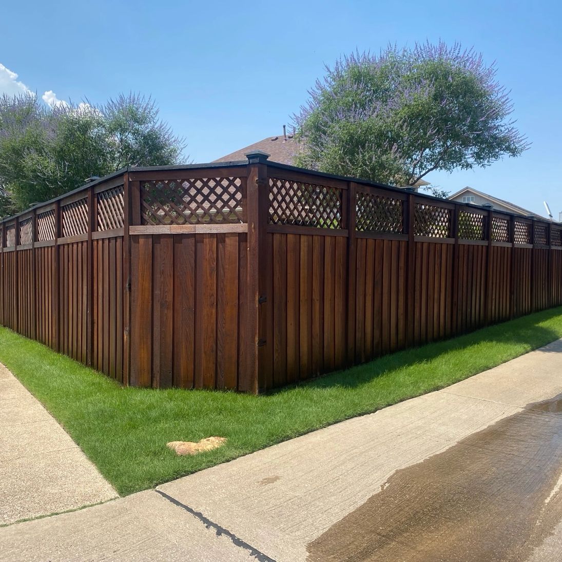 Lone Wolf Staining dark walnut finish on a wood privacy fence